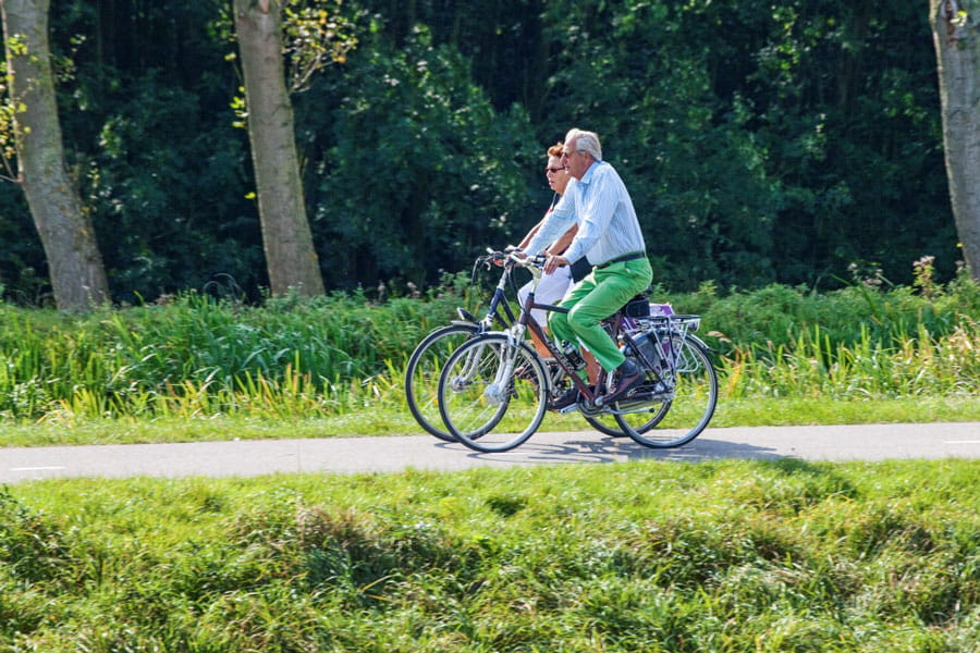 Man en vrouw fietsen door groen gebied