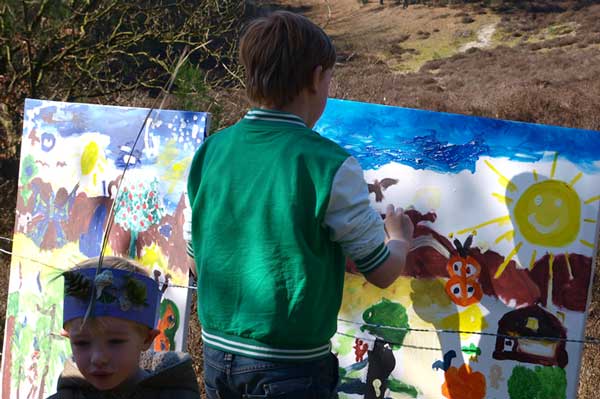 Een kind werkt aan een schilderij in een heidegebied