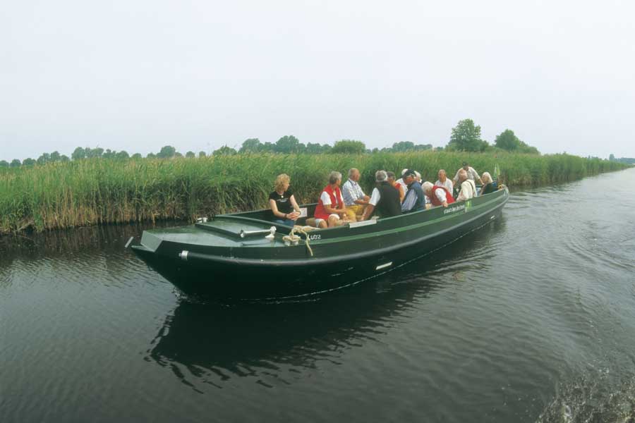 Een groep mensen maakt een boottocht met de boswachter in een natuurgebied