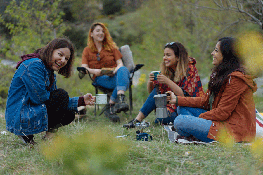Vier jongere vrouwen picknicken in de natuur