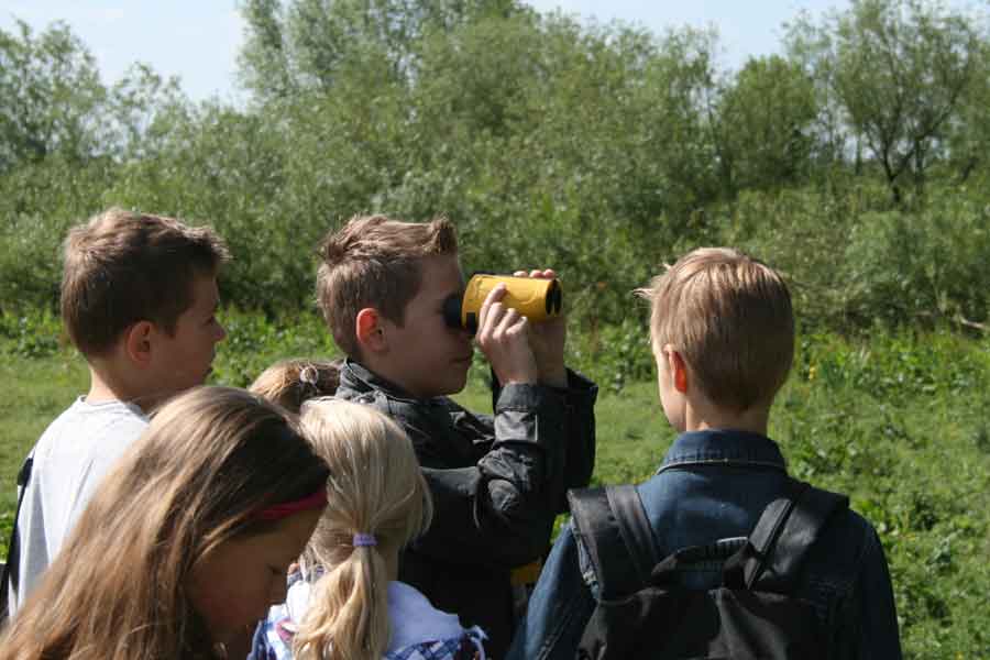 Kinderen met een verrekijker tijdens Expeditie Loevestein in de Bommelerwaard