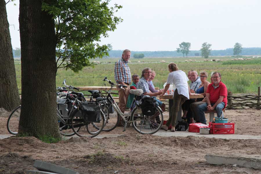 Fietsers op een bankje bij familiepad Noordenveld in heidegebied Dwingelderveld
