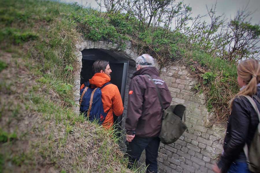 bezoekers lopen een bunker binnen