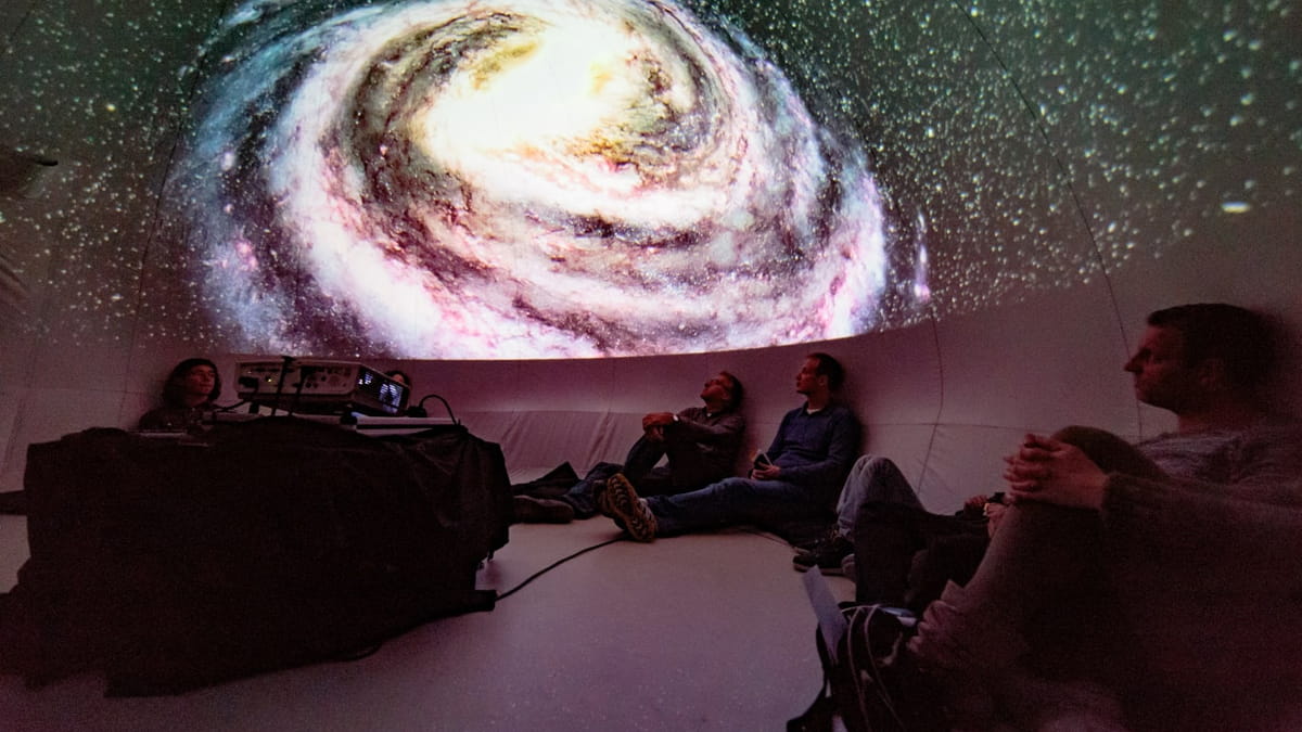Mensen kijken naar het heelal vanuit het planetarium