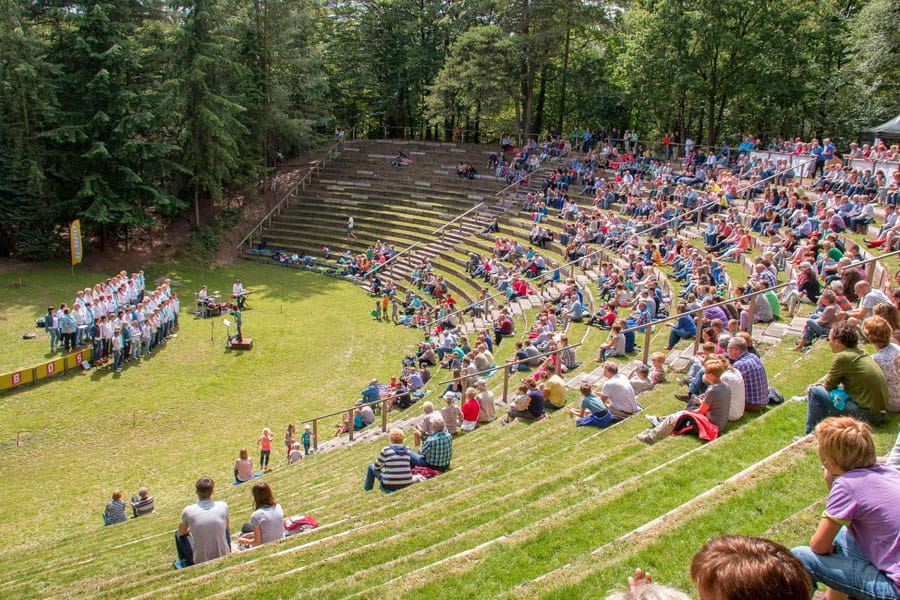 Mensen wonen een voorstelling bij in het openluchttheater in ommen